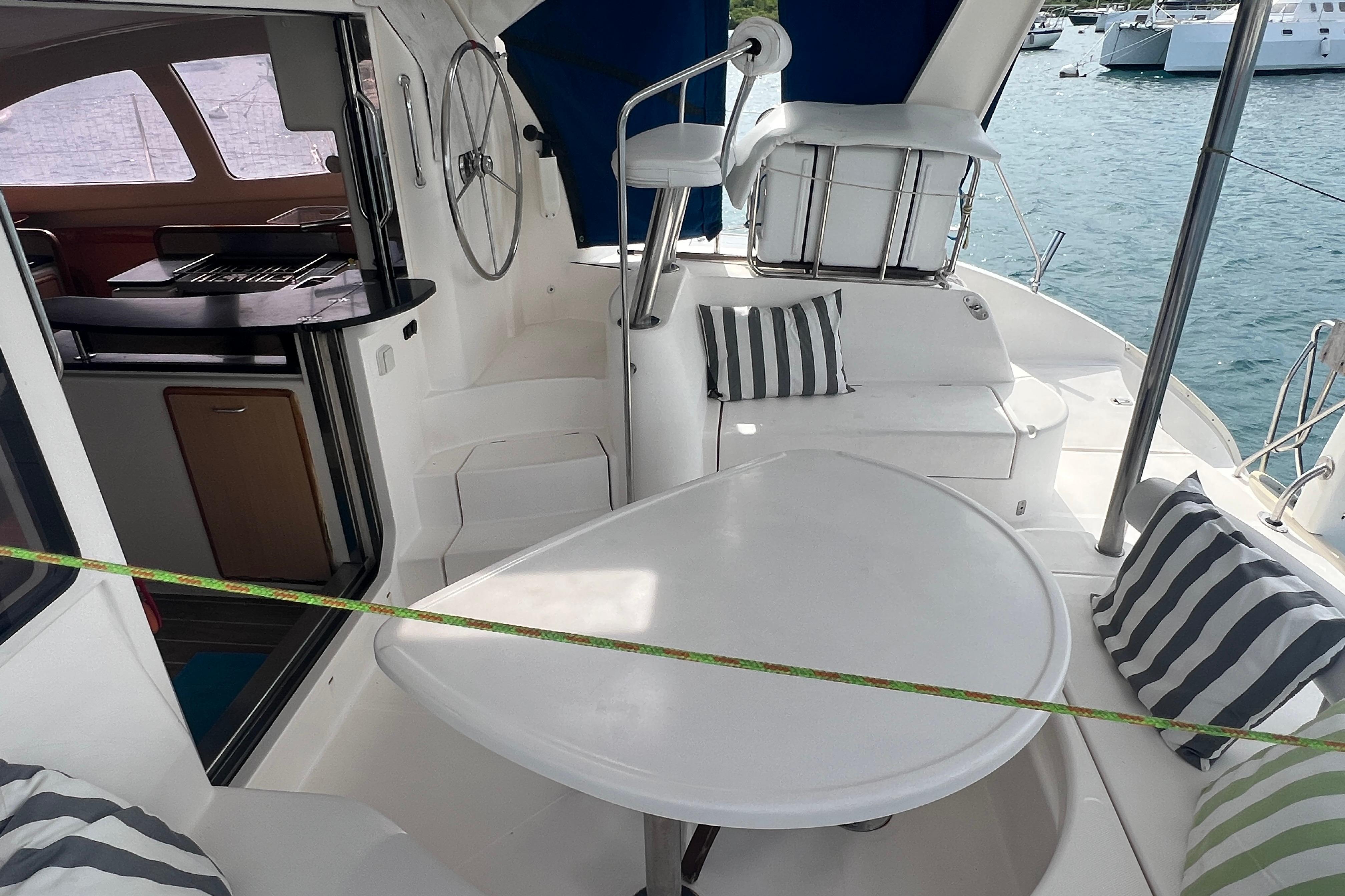 2005 Leopard 40 yacht cockpit with seating, table, and striped cushions, docked by the water.