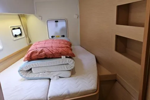 Never Say Never Yacht Photos Pics 2017 Lagoon 42 yacht cabin with cozy bed, pillows, and natural wood accents.