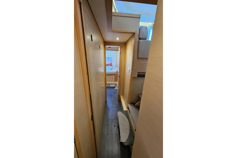 Never Say Never Yacht Photos Pics Interior hallway of 2017 Lagoon 42 catamaran, featuring modern wood paneling and cozy cabin access.