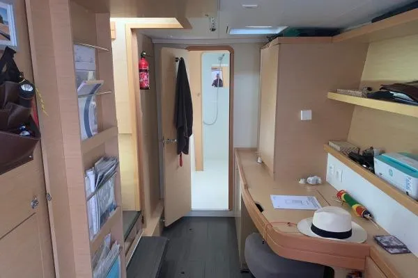 Never Say Never Yacht Photos Pics Interior of 2017 Lagoon 42 catamaran with desk, shelves, and open door to bathroom.