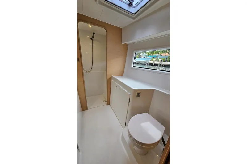 Never Say Never Yacht Photos Pics Bathroom interior of 2017 Lagoon 42 yacht, featuring shower, toilet, and window view.