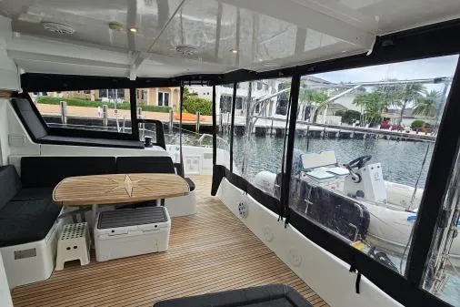 Never Say Never Yacht Photos Pics 2017 Lagoon 42 catamaran interior with seating, table, and marina view.