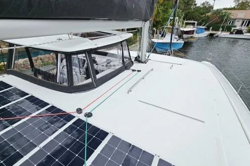 Never Say Never Yacht Photos Pics 2017 Lagoon 42 catamaran with solar panels docked by the water.