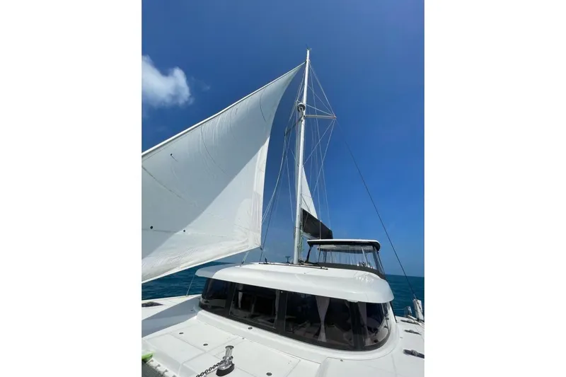 Never Say Never Yacht Photos Pics Sailing Lagoon 42 catamaran, 2017 model, with white sails against a clear blue sky.