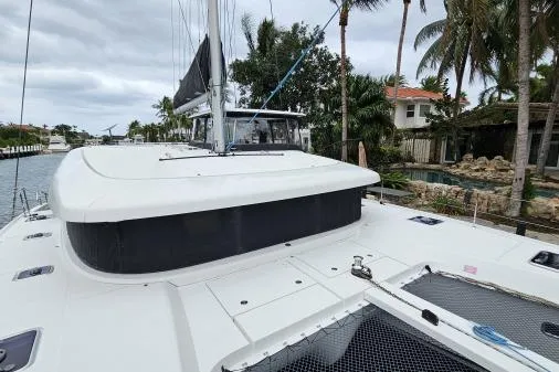 Never Say Never Yacht Photos Pics 2017 Lagoon 42 catamaran docked near tropical waterfront homes.