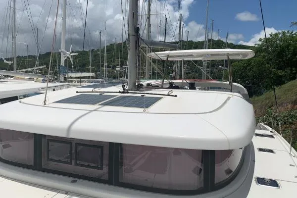 Never Say Never Yacht Photos Pics 2017 Lagoon 42 catamaran with solar panels, docked in a marina.