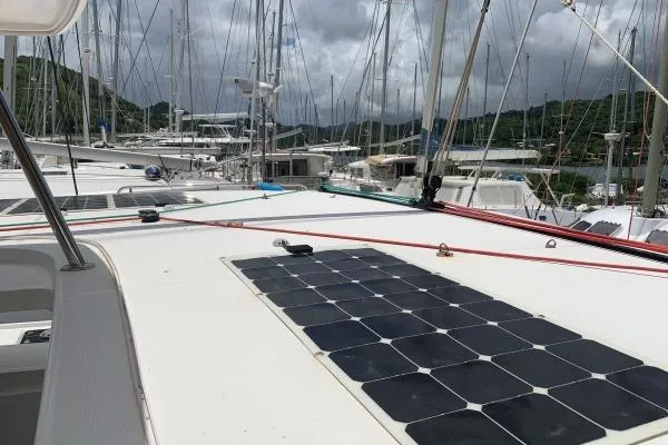 Never Say Never Yacht Photos Pics 2017 Lagoon 42 catamaran with solar panels docked at a marina under cloudy skies.