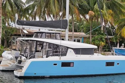 Never Say Never Yacht Photos Pics 2017 Lagoon 42 catamaran docked near tropical palm trees.