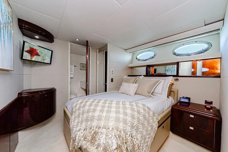 Serendipity Yacht Photos Pics Luxurious bedroom interior of 2001 Lazzara 94 Motor Yacht with elegant decor and porthole windows.