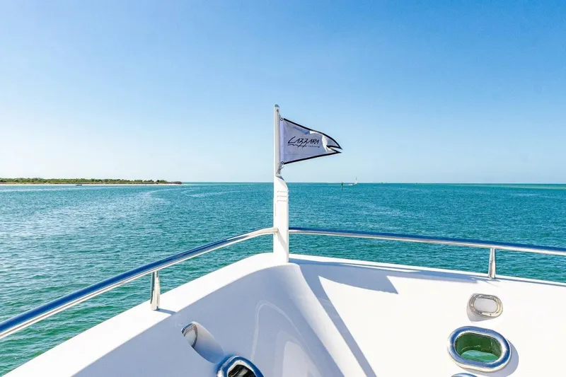 Serendipity Yacht Photos Pics 2001 Lazzara 94 Motor Yacht cruising on clear blue waters under a sunny sky.