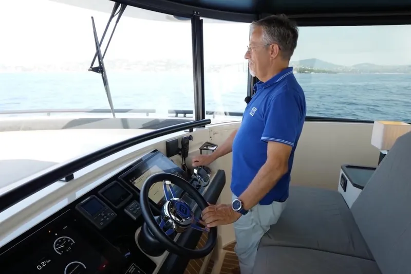  Yacht Photos Pics Man steering 2019 DutchCraft DC56 yacht on open water.