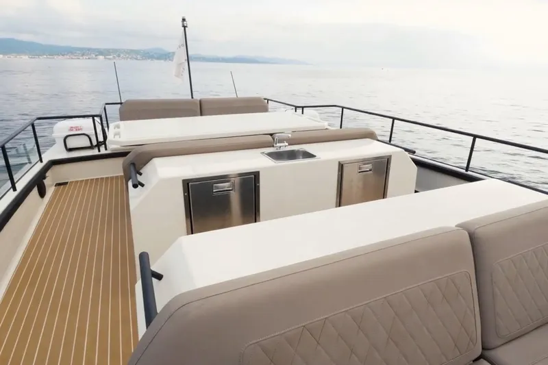  Yacht Photos Pics Luxurious 2019 DutchCraft DC56 yacht deck with seating and kitchenette, overlooking serene waters.