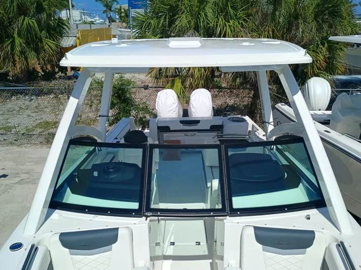 257-155 Yacht Photos Pics 2025 Robalo R257 Dual Console boat with open deck and seating, surrounded by palm trees.