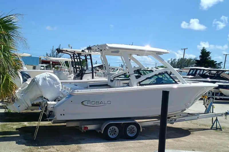 257-155 Yacht Photos Pics 2025 Robalo R257 Dual Console boat on trailer, sunny day, marina background.