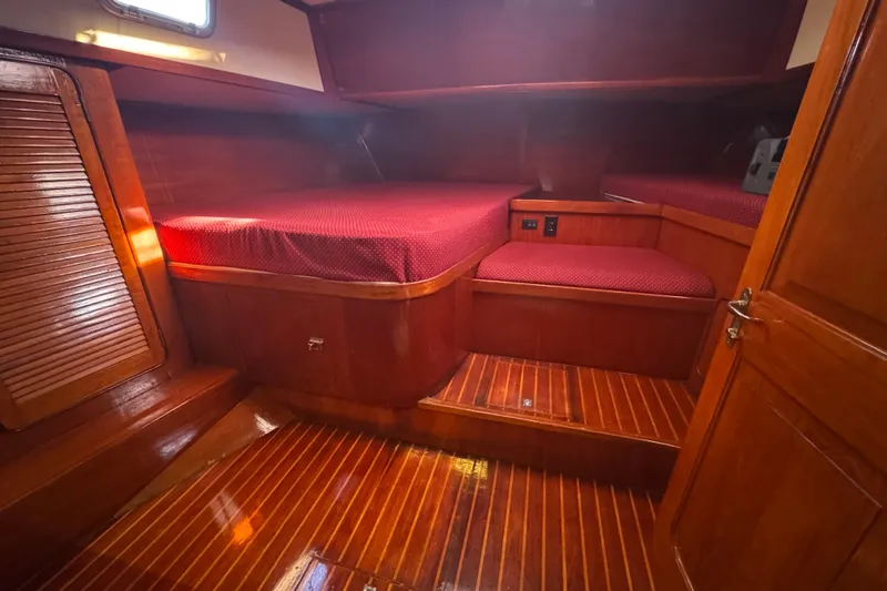 Independence Yacht Photos Pics 1981 Gulfstar 60 CC yacht cabin with polished wood and red bedding.