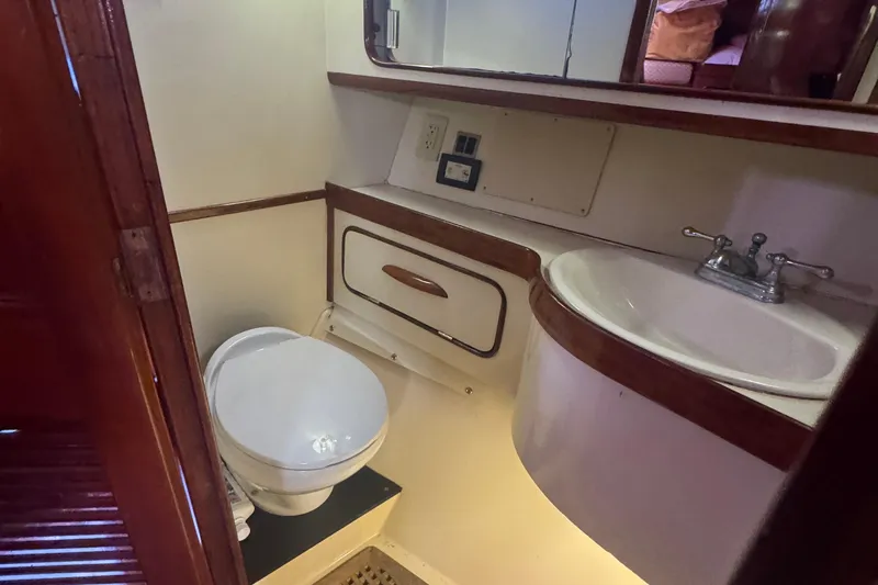 Independence Yacht Photos Pics 1981 Gulfstar 60 CC yacht bathroom with toilet, sink, and wooden cabinetry.