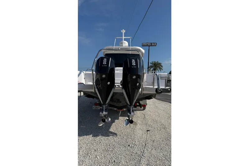  Yacht Photos Pics 2023 Axopar 37 XC CROSS CABIN with dual 300 V8 engines, parked on gravel.