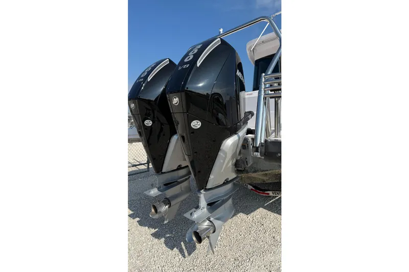  Yacht Photos Pics Twin Mercury outboard engines on 2023 Axopar 37 XC CROSS CABIN boat, parked on gravel.