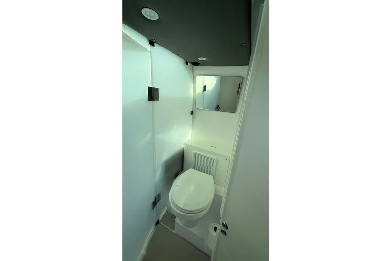  Yacht Photos Pics Compact bathroom in 2023 Axopar 37 XC CROSS CABIN with toilet and mirror.