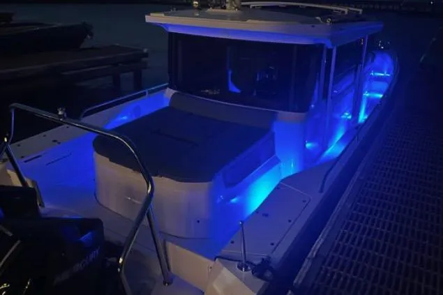  Yacht Photos Pics 2023 Axopar 37 XC CROSS CABIN boat with blue LED lights at night.