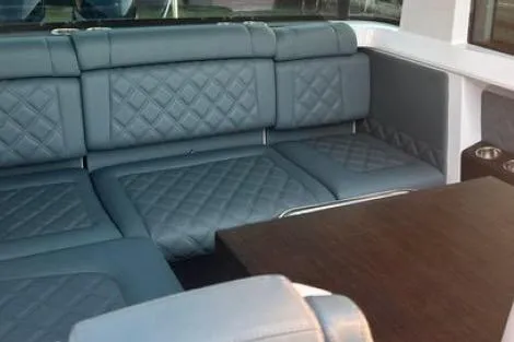  Yacht Photos Pics Luxurious interior of 2023 Axopar 37 XC CROSS CABIN with quilted seating and wooden table.