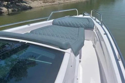  Yacht Photos Pics 2023 Axopar 37 XC CROSS CABIN boat with cushioned deck, docked on calm water.