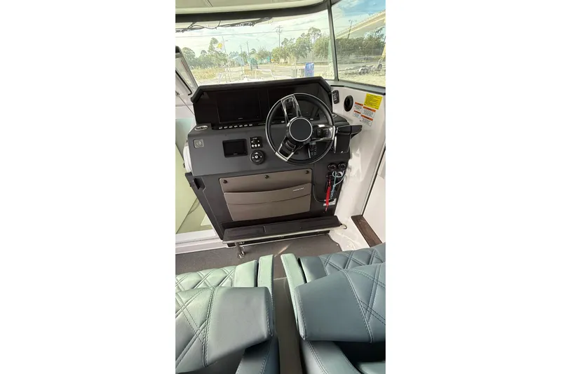  Yacht Photos Pics Interior view of 2023 Axopar 37 XC CROSS CABIN helm with steering wheel and controls.