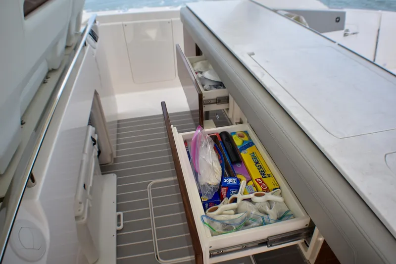 Str8to Yacht Photos Pics 2025 Tiara Yachts 43 LS yacht interior with open storage drawer and kitchen supplies.