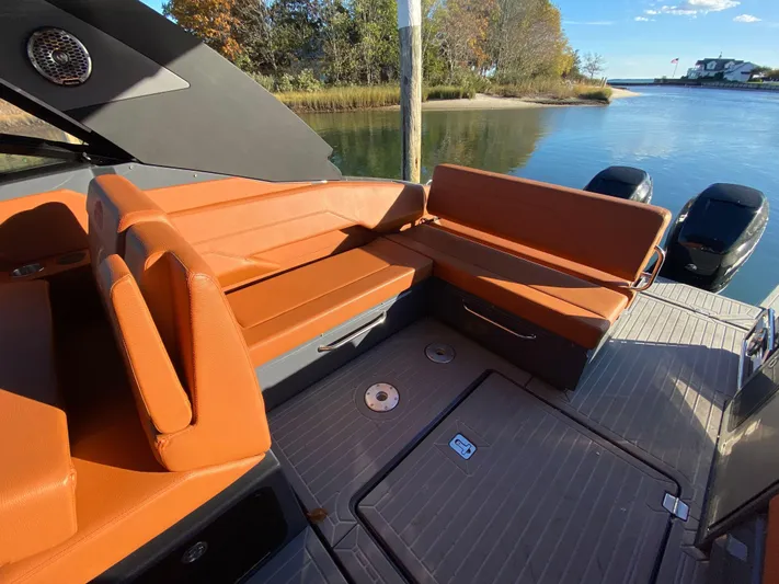  Yacht Photos Pics 2023 Cruisers Yachts 34 GLS OB with orange seating, docked by a serene waterway.