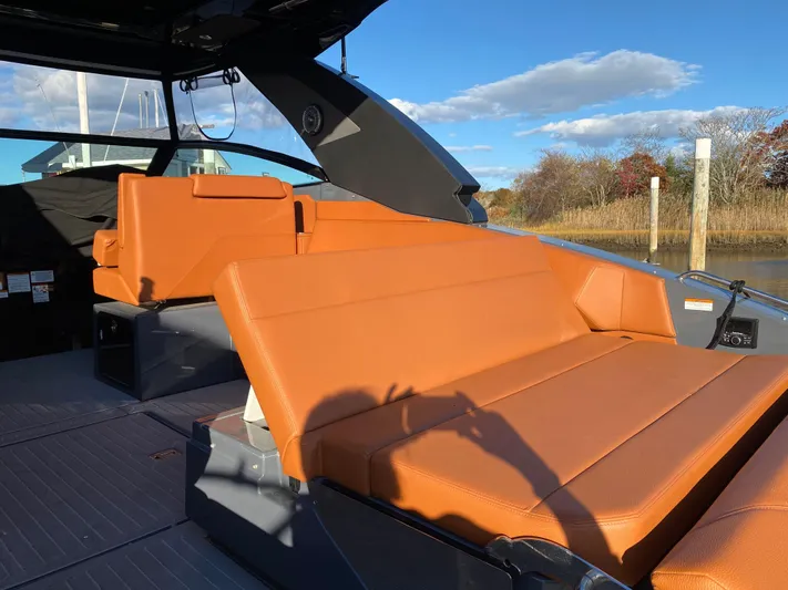  Yacht Photos Pics 2023 Cruisers Yachts 34 GLS OB with orange seating, docked under blue sky.