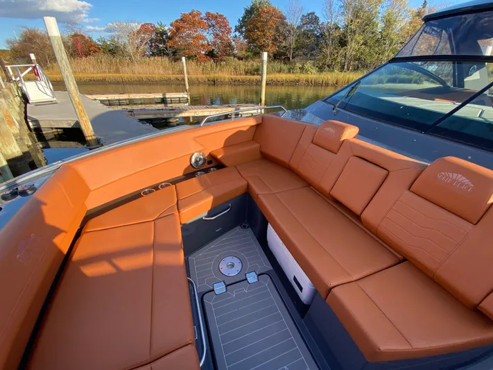  Yacht Photos Pics 2023 Cruisers Yachts 34 GLS OB with luxurious tan seating in a serene marina setting.