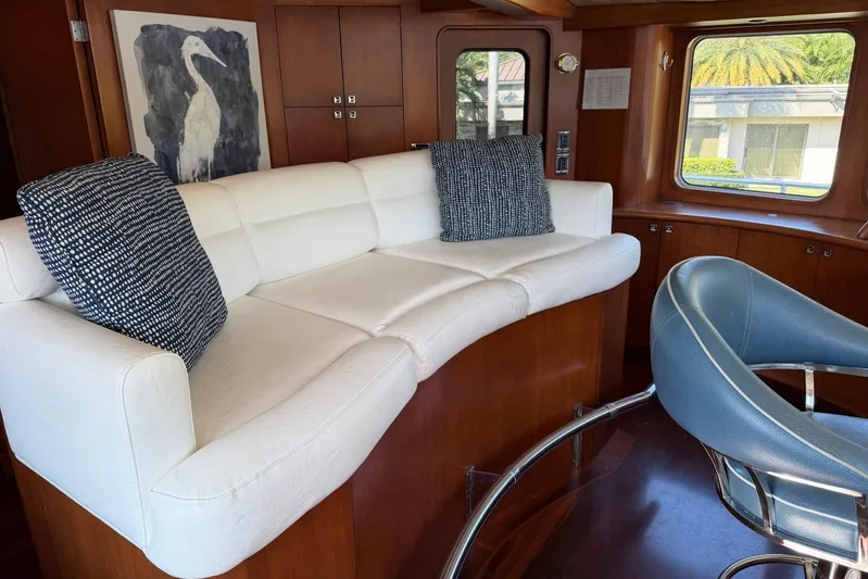  Yacht Photos Pics Luxurious Heesen 144 yacht interior with white sofa, blue chair, and elegant wood paneling.