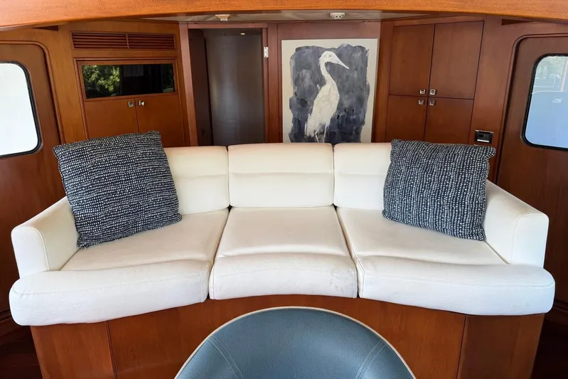  Yacht Photos Pics Luxurious Heesen 144 yacht interior with white sofa, decorative pillows, and elegant wood paneling.