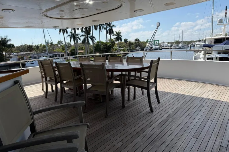  Yacht Photos Pics Outdoor dining area on 1990 Heesen 144 yacht with marina view.