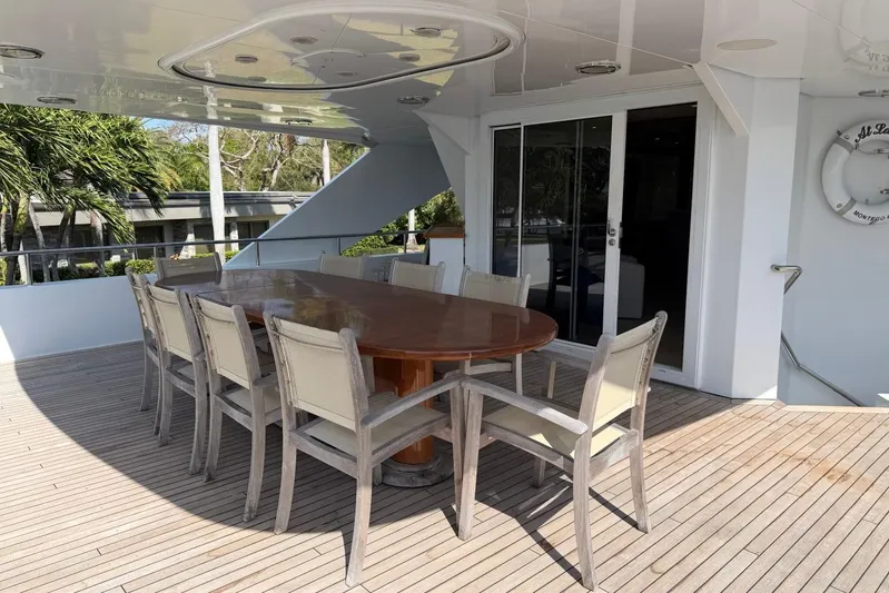  Yacht Photos Pics Outdoor dining area on 1990 Heesen 144 yacht with wooden table and chairs.