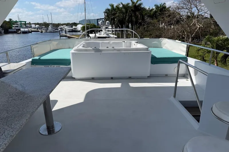  Yacht Photos Pics Luxurious Heesen 144 yacht deck with jacuzzi and seating, docked by a scenic marina.