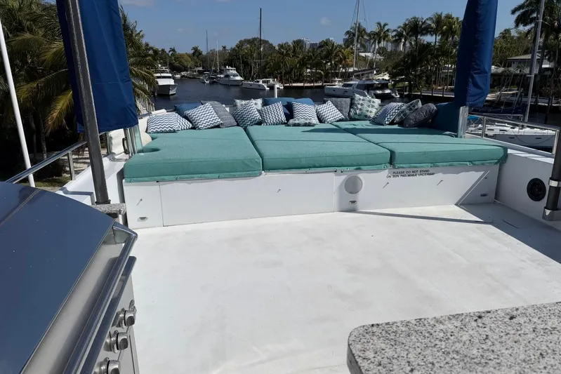  Yacht Photos Pics Luxurious Heesen 144 yacht deck with sunbathing area, cushions, and scenic marina view.