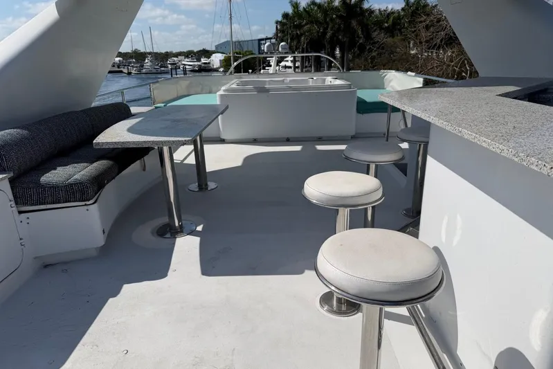  Yacht Photos Pics Luxurious 1990 Heesen 144 yacht deck with seating, tables, and bar stools.