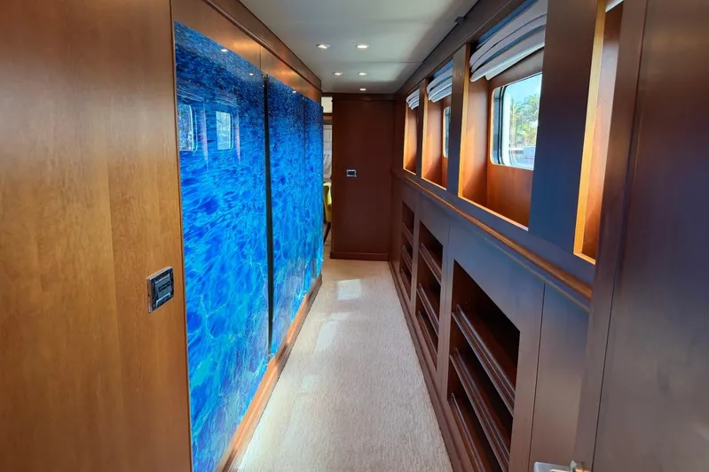  Yacht Photos Pics Luxurious hallway interior of 1990 Heesen 144 yacht with wood paneling and blue artwork.