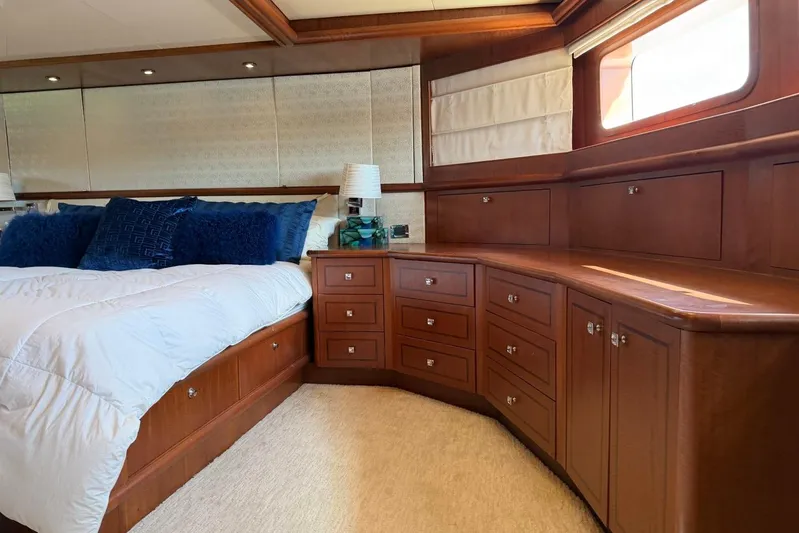  Yacht Photos Pics Luxurious bedroom interior of 1990 Heesen 144 yacht with elegant wood cabinetry and plush bedding.