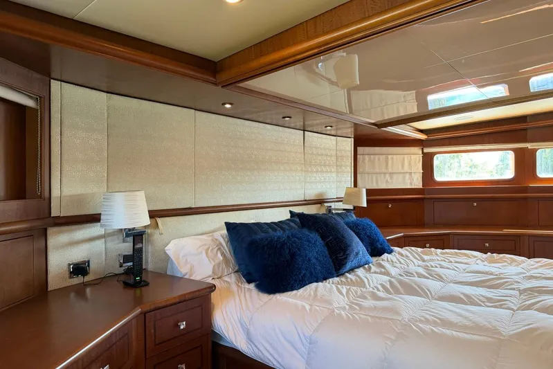  Yacht Photos Pics Luxurious bedroom interior on 1990 Heesen 144 yacht with elegant wood paneling and plush bedding.