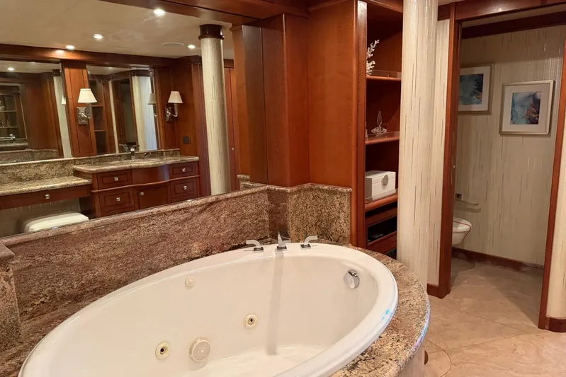  Yacht Photos Pics Luxurious bathroom with jacuzzi on 1990 Heesen 144 yacht, featuring elegant wood and marble finishes.