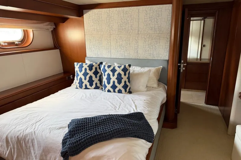  Yacht Photos Pics Luxurious bedroom interior on 1990 Heesen 144 yacht, featuring elegant wood paneling and stylish decor.