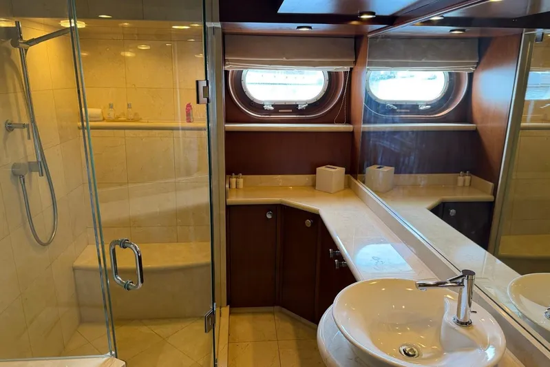  Yacht Photos Pics Luxurious yacht bathroom with glass shower, porthole windows, and elegant fixtures on Heesen 144, 1990.