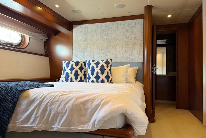  Yacht Photos Pics Luxurious bedroom interior on a 1990 Heesen 144 yacht, featuring elegant bedding and wood accents.