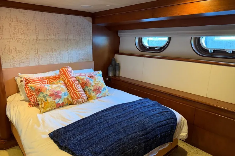  Yacht Photos Pics Luxurious bedroom interior on 1990 Heesen 144 yacht with colorful pillows and porthole windows.