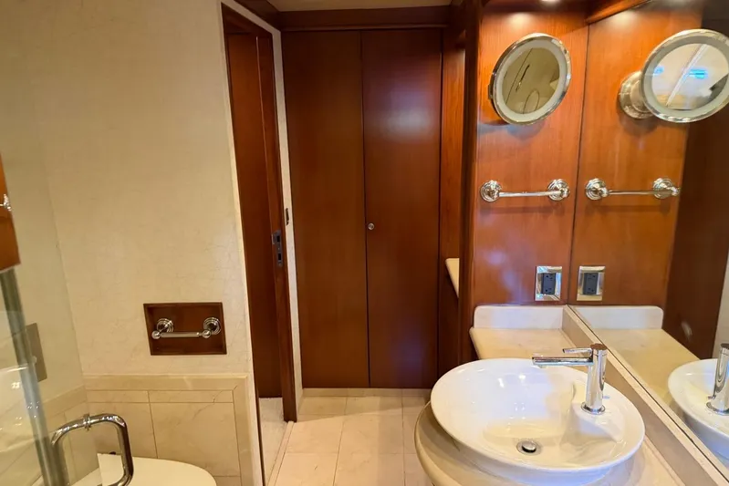  Yacht Photos Pics Luxurious yacht bathroom with wooden accents, round mirrors, and modern sink. Heesen 144, 1990.