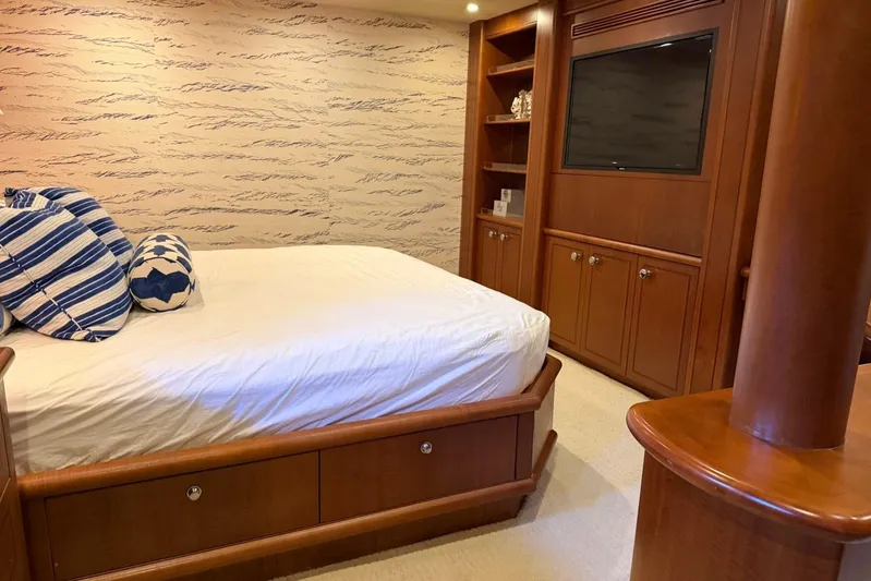  Yacht Photos Pics Luxurious bedroom interior on 1990 Heesen 144 yacht with wood furnishings and striped pillows.