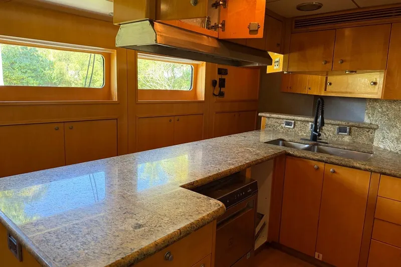  Yacht Photos Pics Luxurious kitchen interior of 1990 Heesen 144 yacht with granite countertops and wooden cabinetry.
