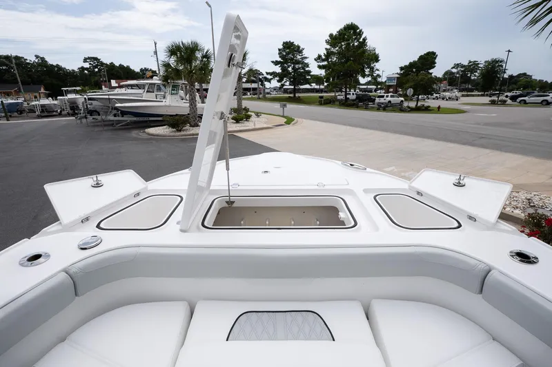  Yacht Photos Pics 2026 Blackfin 262 HB boat with open storage compartment, docked in a marina.